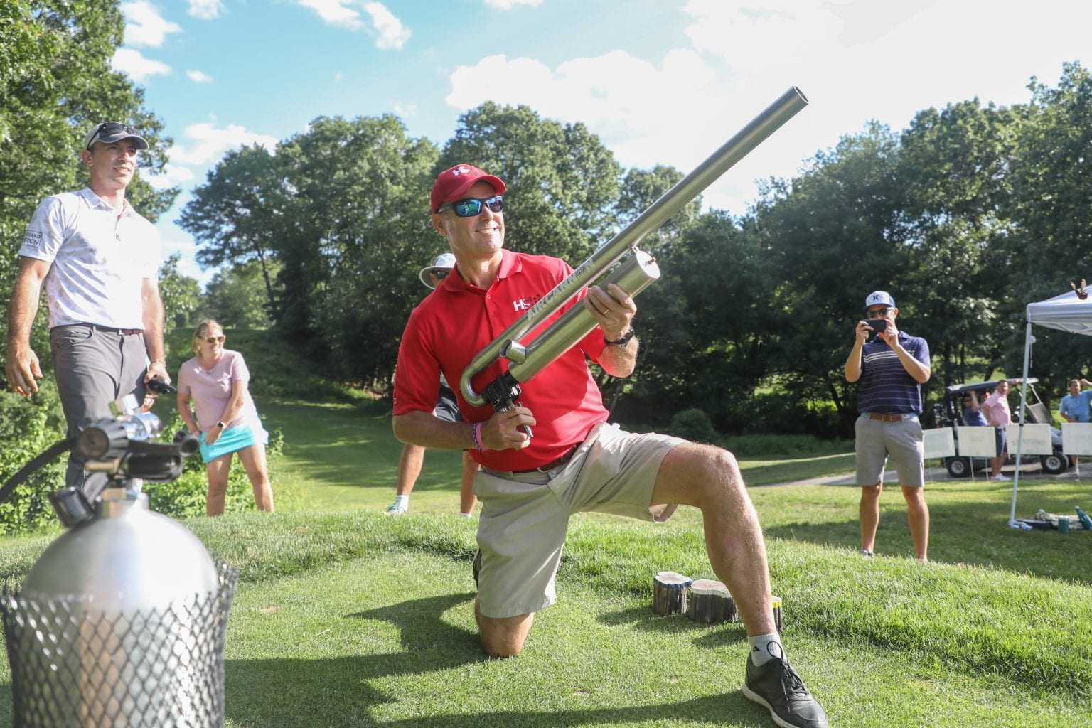 Golfer shooting air rifle at golf tourney. Photo by Joshua Ross